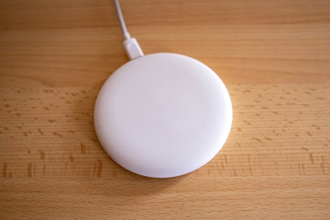 A wireless phone charging pad resting on a desk