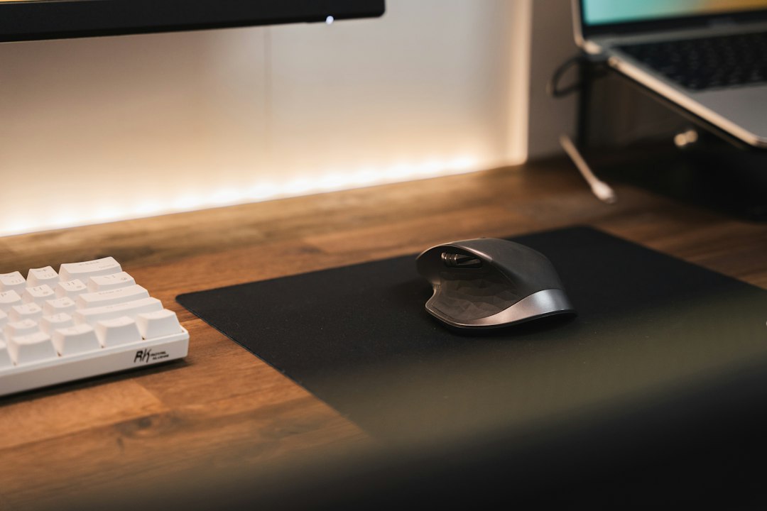 A computer mouse and keyboard side by side on a light desk