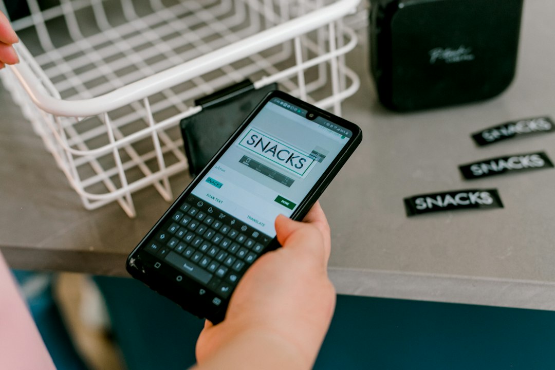 A hand typing label text into a label maker app to print pantry labels