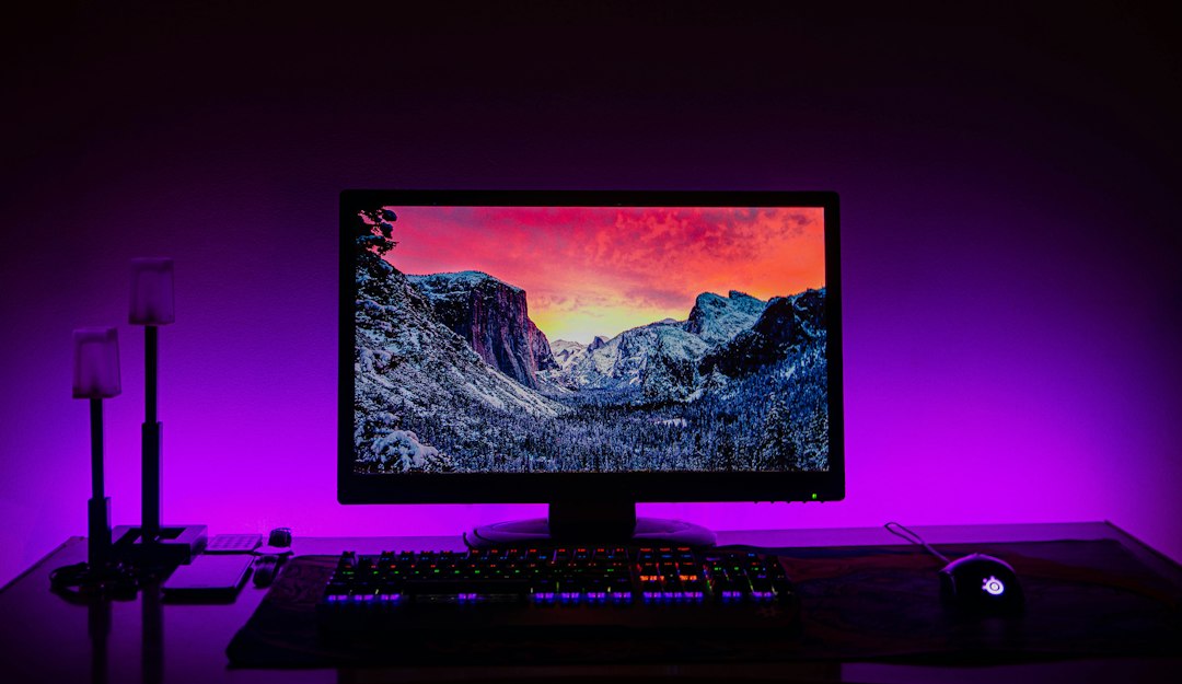 A black flat screen computer monitor in shallow focus on a desk