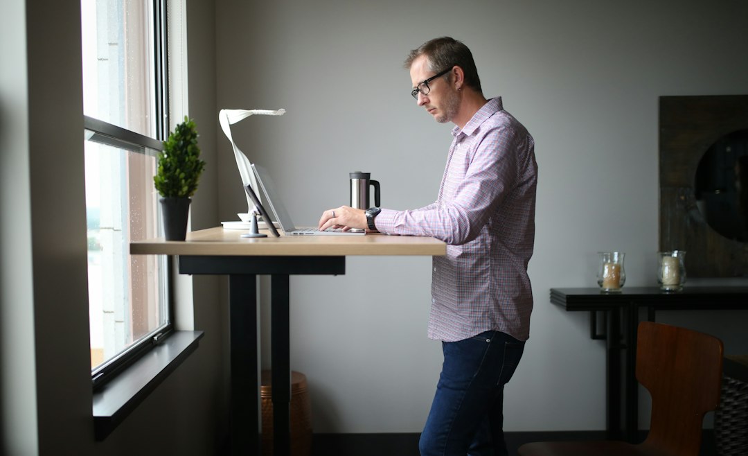 A home office desk set up for standing work, with the screen raised above the worktop